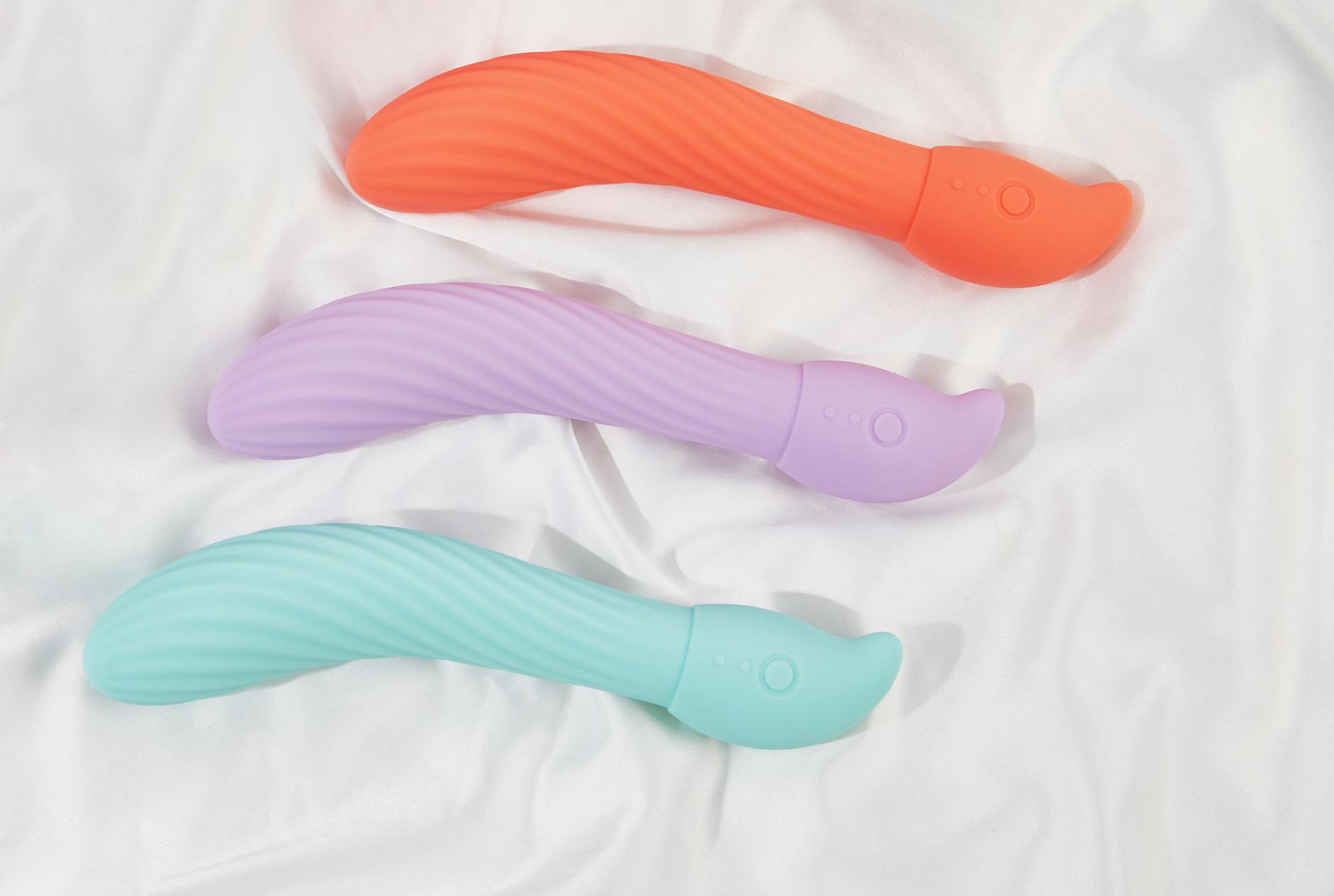 Three colorful lemon vibrators displayed on white fabric, showing their sleek design and texture.