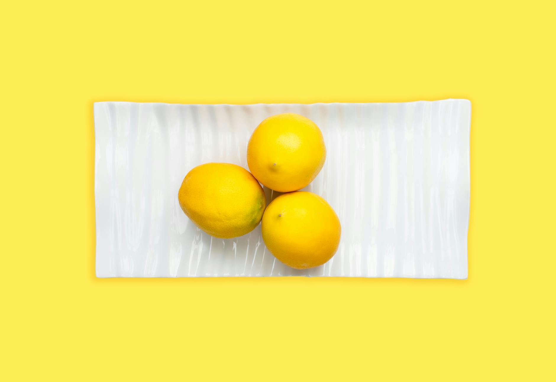 Fresh cut lemon halves on a pink background in sunlight