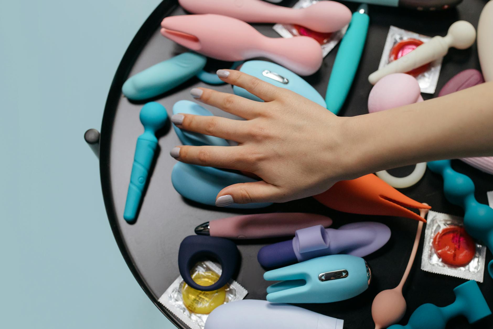Woman holding vibrators in contemplative moment of self-discovery